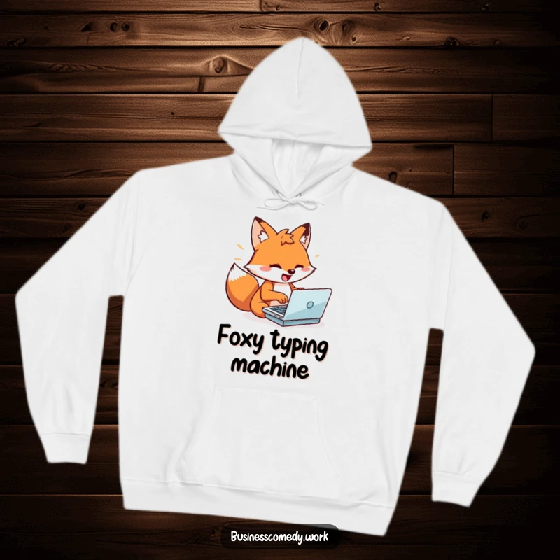 Funny playful fox typing on a laptop on a hoodie, looking energized and fast, a cozy and humorous item.
